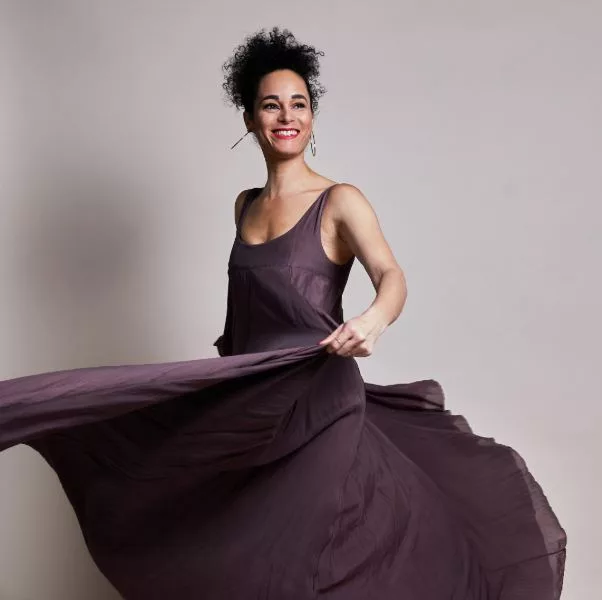Ariane Roth – Membership 05 Ariane Roth im fließenden Kleid tanzt mit offenem Lächeln – Ausdruck von Lebendigkeit, Präsenz und künstlerischer Freiheit.